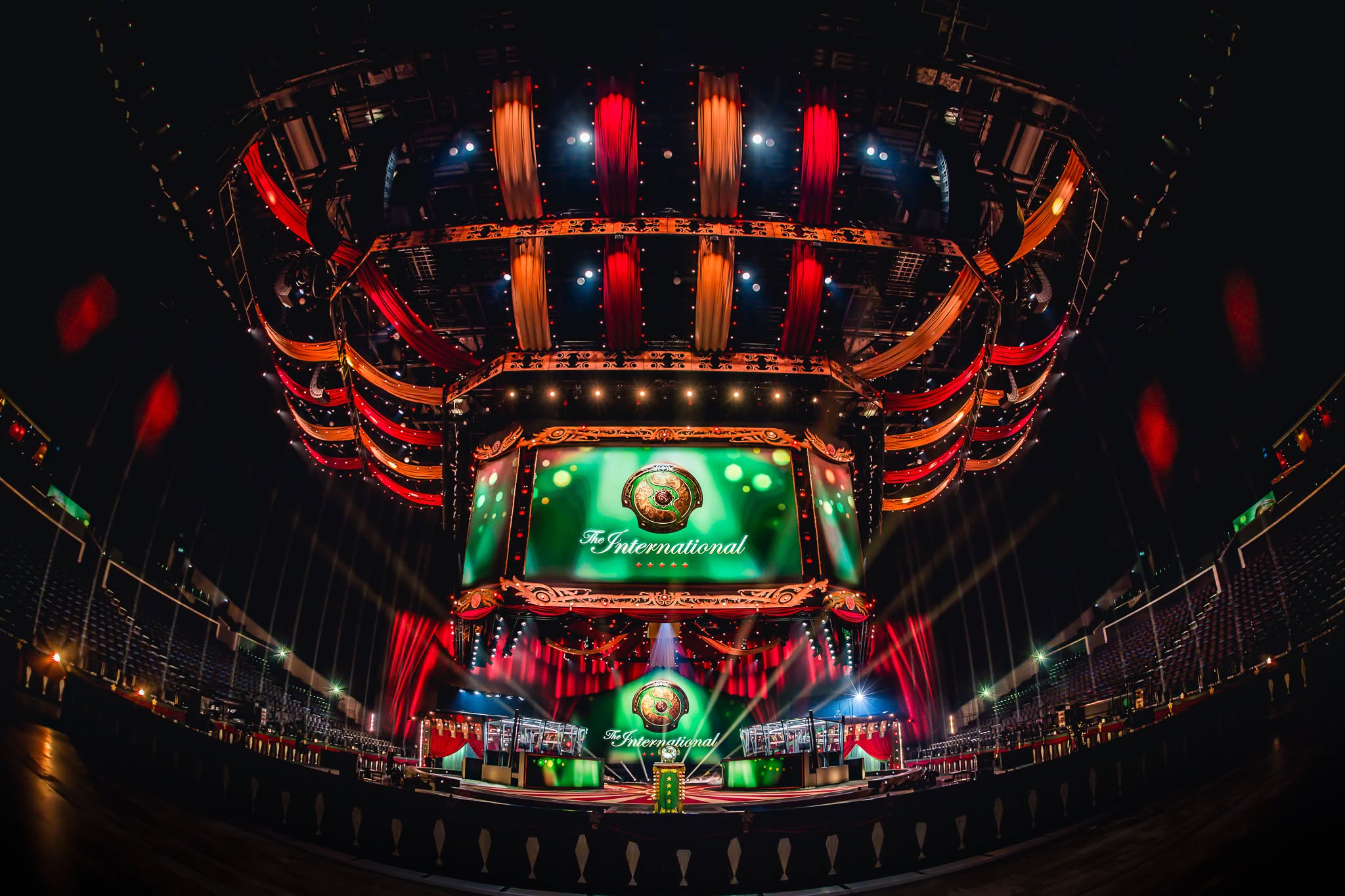 The International stage before doors: circus-themed rig with red and orange drapes over the LED screen and the Aegis trophy centre stage