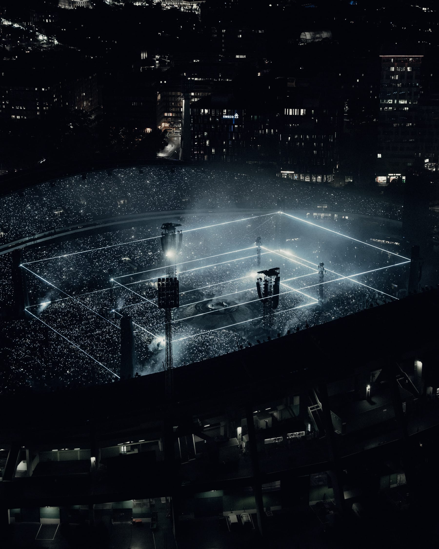 Swedish House Mafia at Ullevi seen from above at night, a grid of light beams over a crowd of phone lights